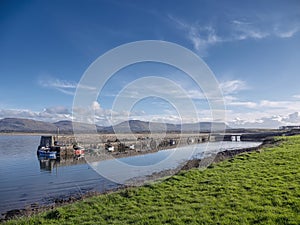 Mullaghmore pier and beautiful nature scenery in the background. Warm sunny day with blue cloudy sky. Popular travel area. Ireland