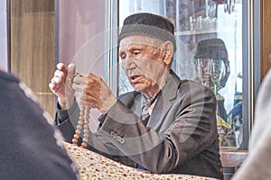 Mullah talking counting rosary at rural house. photo