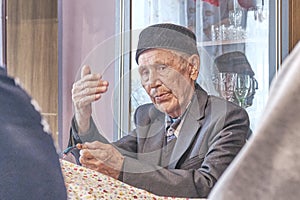 Mullah talking gesturing with his hands at rural house