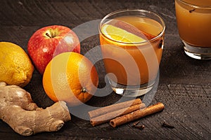 Mulled Wassail Cider with cinnamon sticks and orange slice slightly above shot