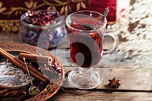 Mulled wine with a badge and cardamom in a glass on a wooden table top