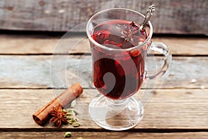 Mulled wine with a badge and cardamom in a glass on a wooden table top