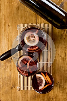 Mulled wine in glasses with bottle on wooden background,top view