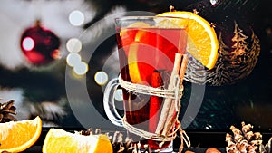 Mulled wine Hot christmas drink with spices on a dark christmas background. Orange slices, cinnamon sticks, christmas cones,