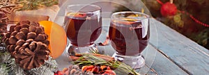 Mulled wine hot drink with citrus, apple and spices in a drink glasses.