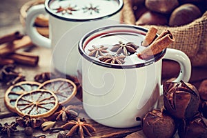 Mulled wine in mugs, dry fruits and chestnuts