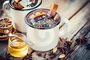 Mulled wine in mugs, dry spice and honey.