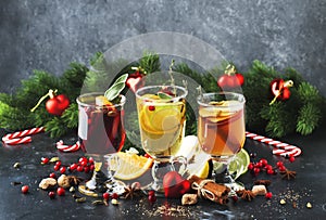 Mulled wine and mulled cider. Hot winter drinks and cocktails for christmas or new year`s eve in glass mugs with spices and citru photo