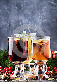 Mulled wine and mulled cider. Hot winter drinks and cocktails for christmas or new year`s eve in glass mugs with spices and citru
