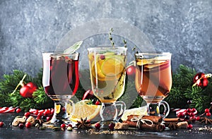 Mulled wine and mulled cider. Hot winter drinks and cocktails for christmas or new year`s eve in glass mugs with spices and citru