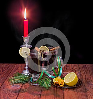 Mulled wine with mulling spices, spruce branches, burning candle