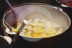 Mulled wine with oranges in large vats on Christmas market. New year and Christmas celebration concept, traditional drink