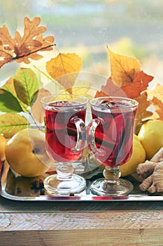 Mulled wine, organic fruits, autumn leaves, spices on a wooden table