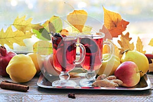 Mulled wine, organic fruits, autumn leaves, spices on a wooden table