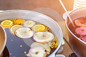 Mulled wine prepared in iron pot at city street fair. Traditional christmas and new year alcohol drink - hot wine. Stall with