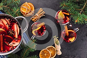 Mulled wine or punch in a glass and hot wine in a cooking pot with spices and fruits