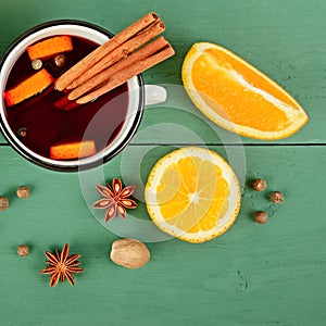 Mulled wine in rustic mugs with spices and citrus fruit