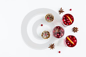 Mulled wine in small glasses with cranberries, anise and oranges. White background, top view