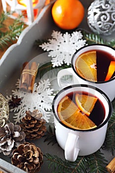 Mulled wine with spices and citrus fruit on vintage tray