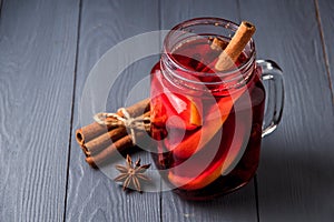 Mulled wine and spices on gray wooden background. Selective focus.