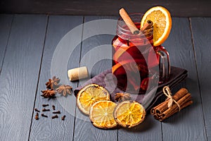 Mulled wine and spices on gray wooden background. Selective focus.