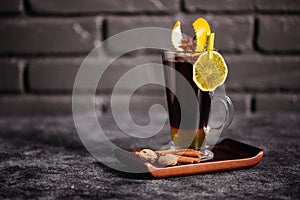 Mulled wine and spices on stone background.