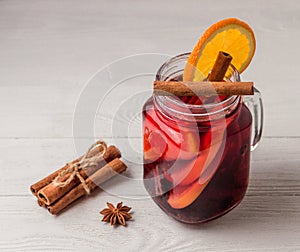 Mulled wine and spices on white wooden background. Selective focus.
