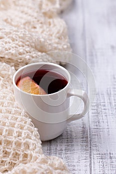 Mulled wine in white porcelain mug with spices and citrus fruit