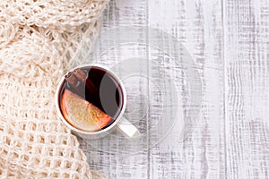 Mulled wine in white porcelain mug with spices and citrus fruit