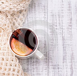 Mulled wine in white porcelain mug with spices and citrus fruit