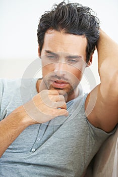 Mulling over memories in the morning. A gorgeous young man lying on a sofa with his arm behind his head and chin rested