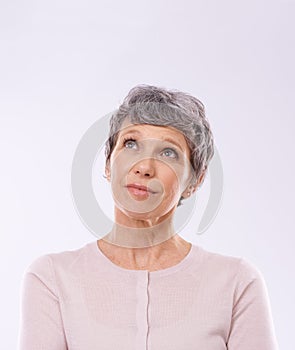 Mulling it over. Studio shot of a thoughtful mature woman against a white background.