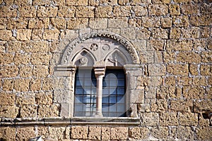 Mullioned window in a tufaceous stone wall, Tuscania, Tuscia, Lazio, Italy