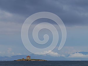The Mulo lighthouse on a rock in the Mediterranean photo