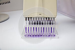 Multi channel pipette loading biological samples in microplate for test in the laboratory / Multichannel pipette load samples in