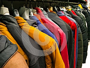 Multi color dress sherwani kurta hanging from hangar in a garment shop for sale
