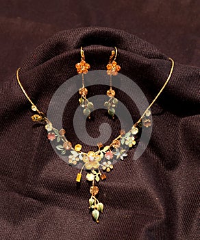 Multi color flower necklace and two earrings in black background