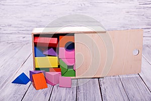 Multi color geometric figures in the wooden box. Education concept.