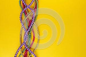 Multi color Mardi Gras beads on paper background. Top view