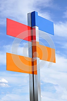Multi color road sign with cloudy sky on