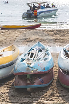 Multi color rowboat or sea kayaks on beach with copy space.