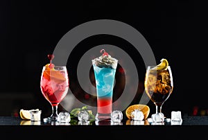 Multi-colored alcoholic cocktails in glasses of different shapes on the bar.