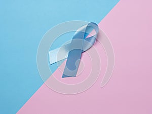 On multi-colored backgrounds pink and blue satin ribbon symbol of prostate cancer awareness. Concept of medicine health