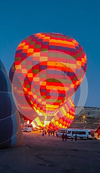 Multi-colored balloons are filled with hot air