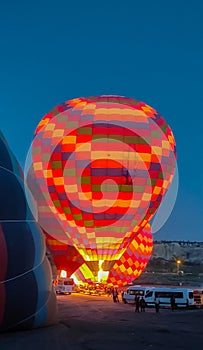 Multi-colored balloons are filled with hot air