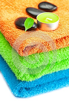 Multi-colored bath towels and black spa stones