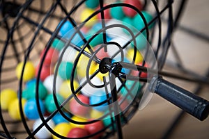 Multi-colored Bingo balls in a cage.