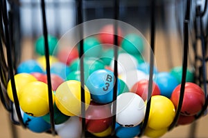 Multi-colored Bingo balls in a cage with B3 ball focused on.