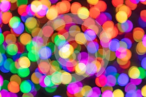 Multi-colored blurred circles of light on a dark background with bokeh effect