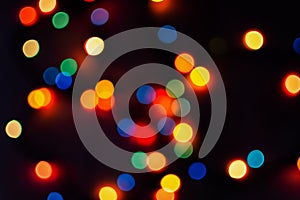 Multi-colored bokeh on a black background. Bright blurry textures of holiday lights